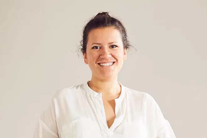 Sophie Kalkum trägt ein weißes Hemd und schaut in die Kamera